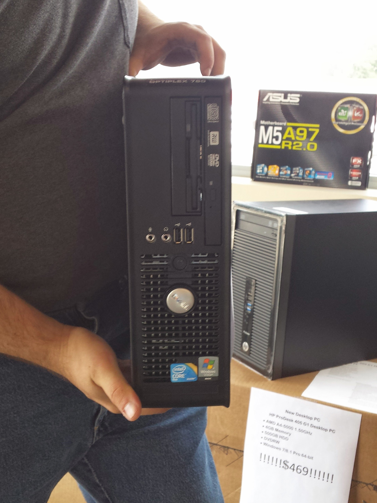 The image shows a person holding a black Dell OptiPlex desktop computer tower. Based on the visual information, this computer could be a Dell OptiPlex GX620 SFF (Small Form Factor) or an OptiPlex 755 model.